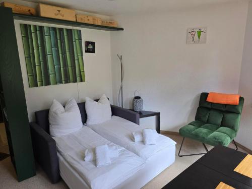 a living room with a couch and a green chair at Ferienwohnung Selva in Lenzerheide