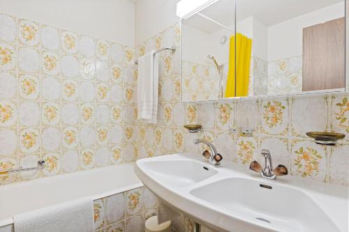 a bathroom with a sink and a mirror and a tub at Triangel D Grossenberger in Parpan