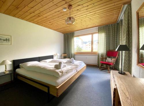 a bedroom with a large bed and a wooden ceiling at Triangel C Kiefer in Parpan