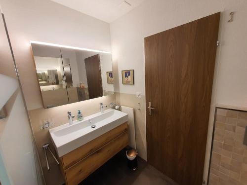 a bathroom with a sink and a large mirror at Triangel C Kiefer in Parpan
