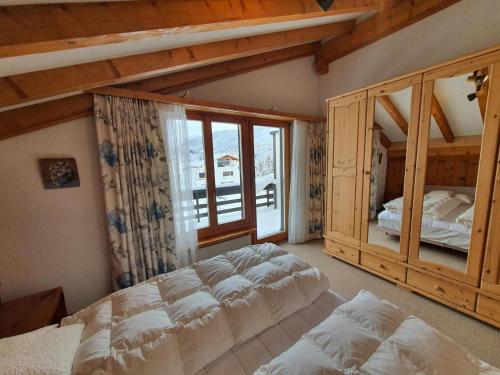 a bedroom with a large bed and a large window at La Schmetta 65 Quadroni in Lenzerheide