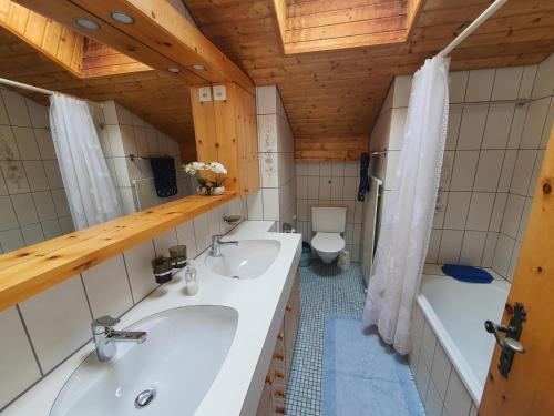 a bathroom with two sinks and a tub and a toilet at La Schmetta 65 Quadroni in Lenzerheide
