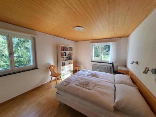 a bedroom with a large bed with a wooden ceiling at Ferienhaus Tina in Lenzerheide