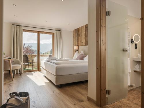 a hotel room with a bed and a balcony at Bachmanngut in St. Wolfgang