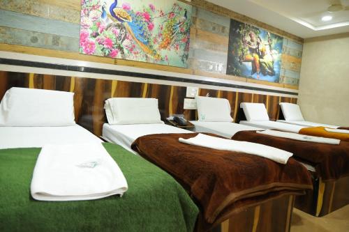 a row of beds in a room at SSR Hotel in Srikalahasti