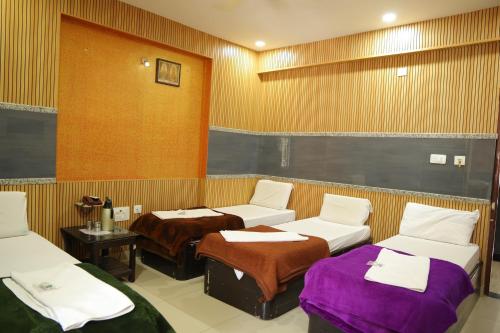 a room with three beds in a room at SSR Hotel in Srikalahasti