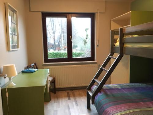 a bedroom with a bunk bed and a window at Eifelhaus Emmels in Saint-Vith