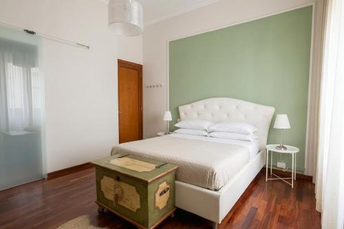 a white bedroom with a white bed and a table at Room & Breakfast D'Annunzio in Ravenna