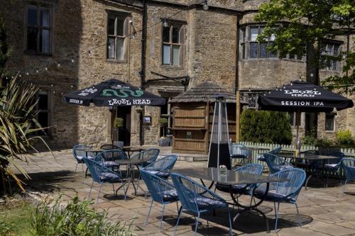 a group of tables and chairs with umbrellas in front of a building at Walworth Castle Hotel, BW Signature Collection in Darlington