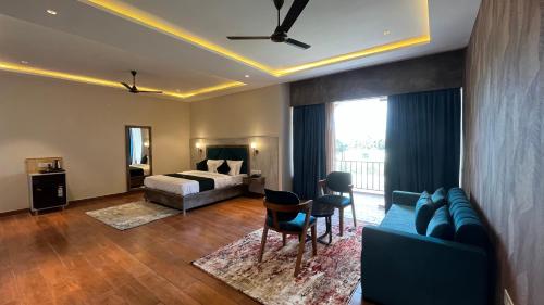 a bedroom with a bed and a couch and a table at Hill Turn Corbett in Rāmnagar