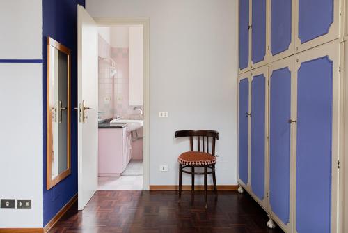 a bathroom with blue walls and a stool in a room at Cristallo apartment in Ravenna