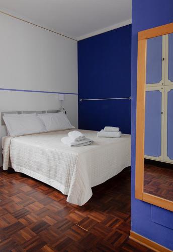 a bedroom with a white bed with blue walls at Cristallo apartment in Ravenna