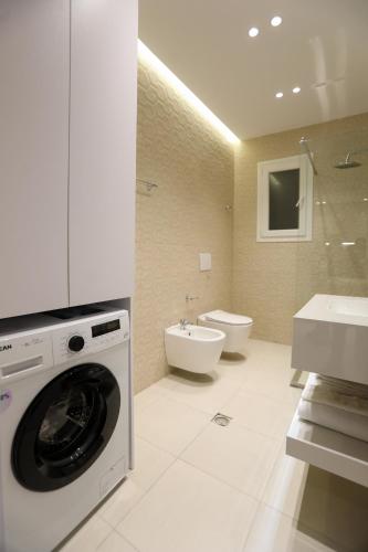 a bathroom with a washing machine and a sink at Alrei Apartment in Vlorë