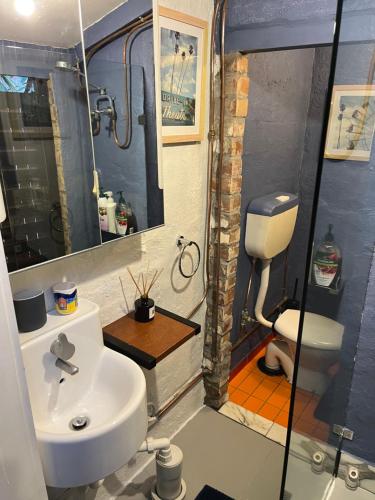 a bathroom with a sink and a toilet at beachside loft warehouse artists retreat in Edithvale