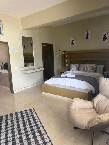 a bedroom with a bed and a chair and a mirror at Pooltjie's Self-catering Overnight in Keetmanshoop