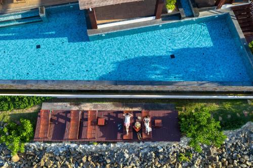 an overhead view of a pool with two people standing next to it at The Sarann Koh Samui, Suites & Villas in Chaweng Noi Beach