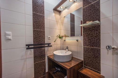 a bathroom with a sink and a mirror at Besenyei Apartman in Sárvár