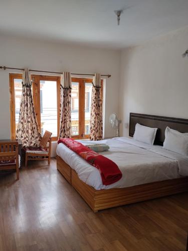 a bedroom with a large bed and a chair at Stendel Villa Fort Road, Leh in Leh
