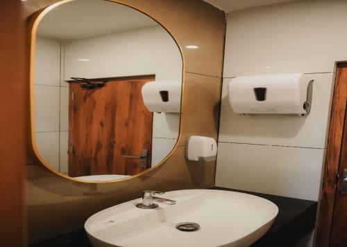 a bathroom with a white sink and a mirror at Hotel Calicut Beach-Silk Street in Kozhikode