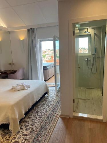 a bedroom with a bed and a glass shower at Captain's Escape - Spa City View in Mali Lošinj