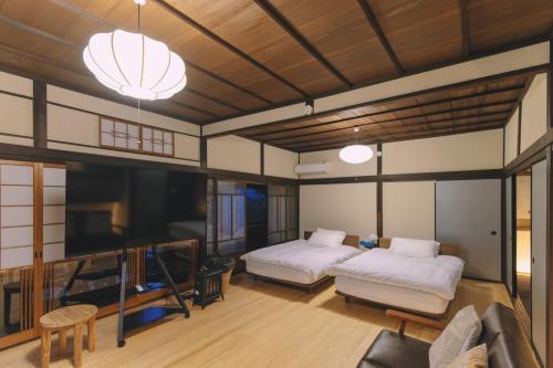 a living room with two beds and a couch at 旧雨今雨 in Onomichi