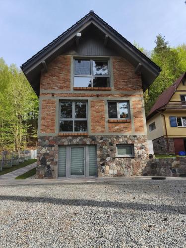 a brick house with two windows and a garage at Dublinkowo in Gołubie