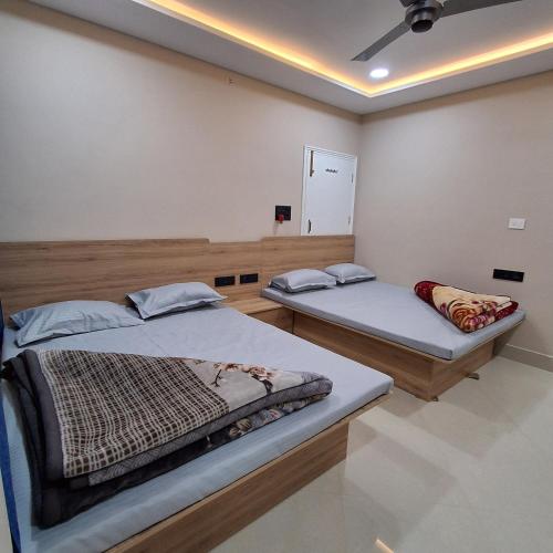 a room with two beds and a ceiling at Royal Homestay Siliguri in Silīguri Junction
