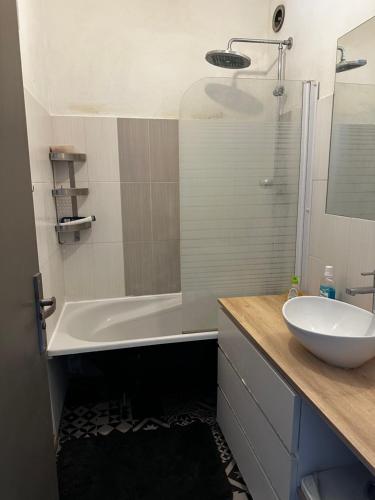a bathroom with a white tub and a sink at Escale Rennes in Rennes