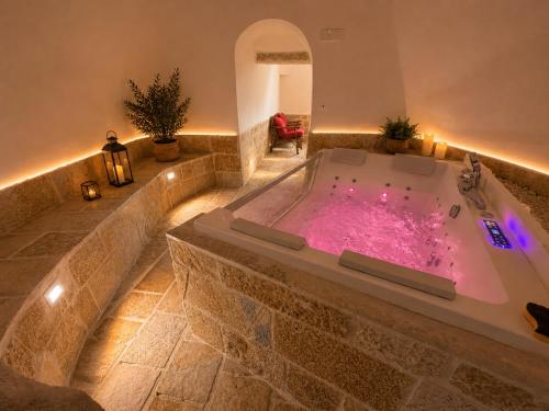a jacuzzi tub with pink water in a room at Tenuta Saracena in Ostuni