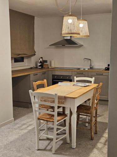 a kitchen with a wooden table and chairs at La Cereria INES in Chiavenna