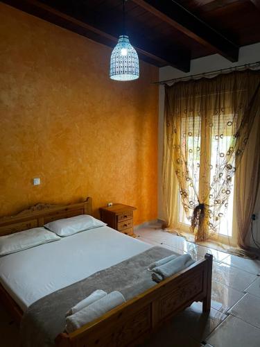 a bedroom with a large bed and a chandelier at Coral Bungalow in Rákhai
