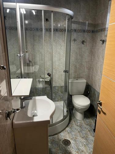 a bathroom with a shower and a toilet and a sink at Coral Bungalow in Rákhai