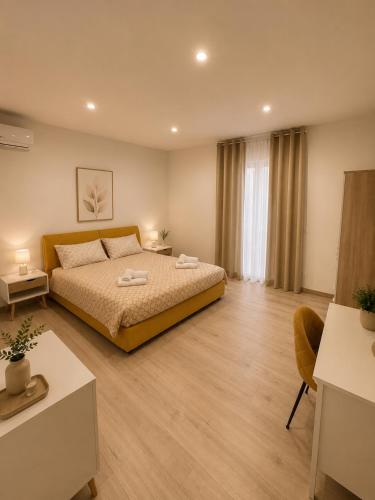 a bedroom with a bed and a table and a room at Tenuta Saracena in Ostuni