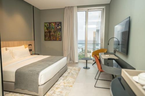 a bedroom with a bed and a desk and a window at Sama Hotels in Dakar