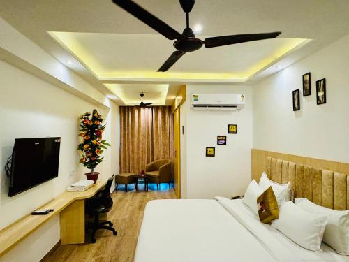 a bedroom with a bed and a desk with a television at Golden Studio With Swimming pool in Jaipur