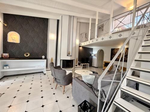 a living room with a spiral staircase and a living room at Natalie Apartments Athens Airport in Artemida