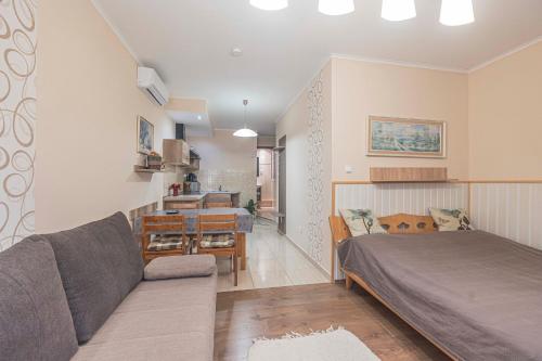 a living room with a bed and a couch at Besenyei Apartman in Sárvár