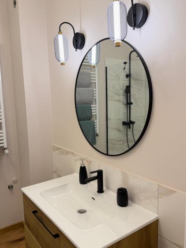 a bathroom with a sink and a mirror at Apartament Londyn in Pniewy