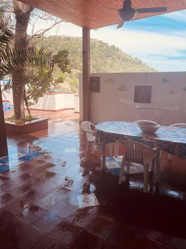a patio with a table and chairs and a palm tree at Villa Iovane Diamond in Ustica