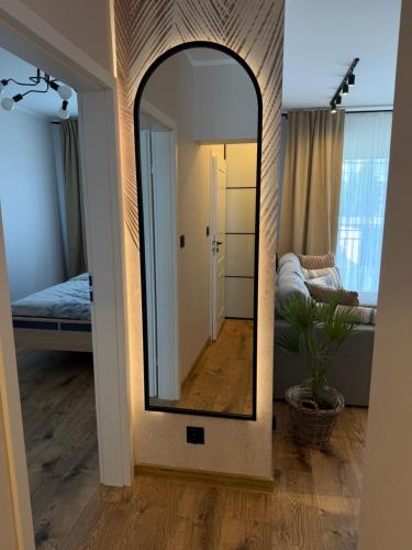 a mirror in a room with a bedroom and a bed at Apartament Londyn in Pniewy