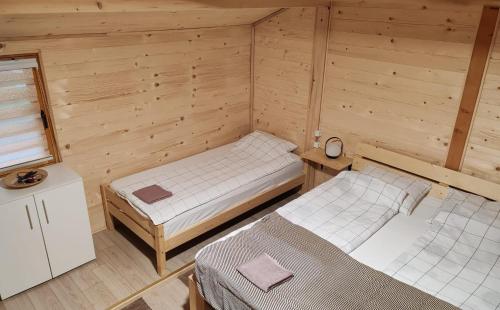 ein Zimmer mit zwei Betten in einer Holzhütte in der Unterkunft Splav Panda in Perućac