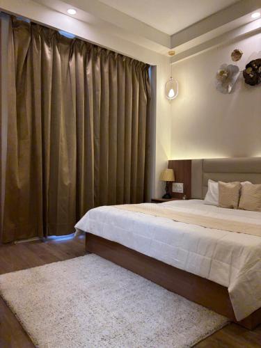 a bedroom with a large bed and a large window at The Kaksh in Greater Noida