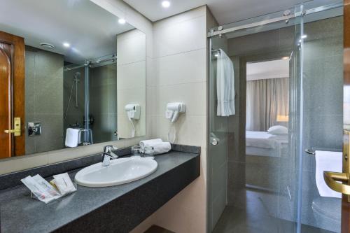 a bathroom with a sink and a shower at Portemilio Hotel & Resort in Jounieh