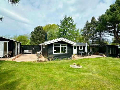 a small house in a yard with a large yard sidx sidx sidx at Charming Beach Cottage In Gilleleje in Gilleleje