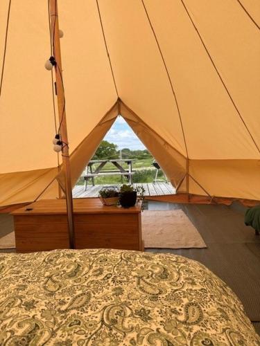 a bedroom with a tent with a view of a field at Glamping Tent - Bell Tent in Brackley
