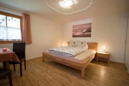a bedroom with a bed and a table and a window at Haus Schönblick in Kirchberg in Tirol