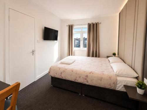 a bedroom with a large bed and a window at Middlesbrough The Longlands Hotel in Middlesbrough