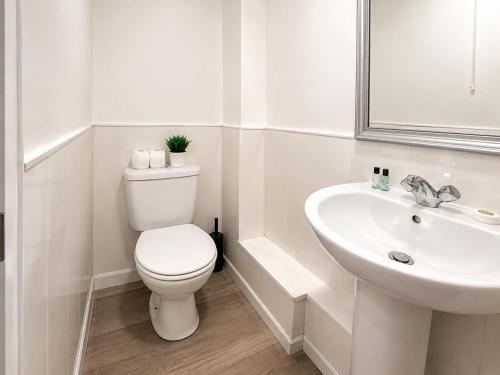 a white bathroom with a toilet and a sink at Middlesbrough The Longlands Hotel in Middlesbrough