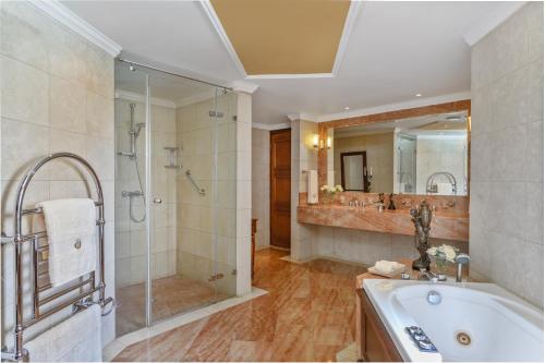 a bathroom with a tub and a shower and a sink at Elysium in Paphos