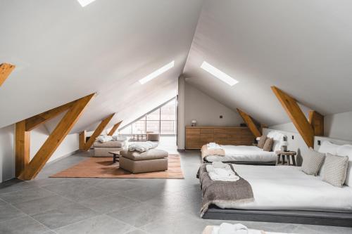 a attic room with two beds and a couch at Les Chalets du Grand Hôtel in Saint-Chaffrey